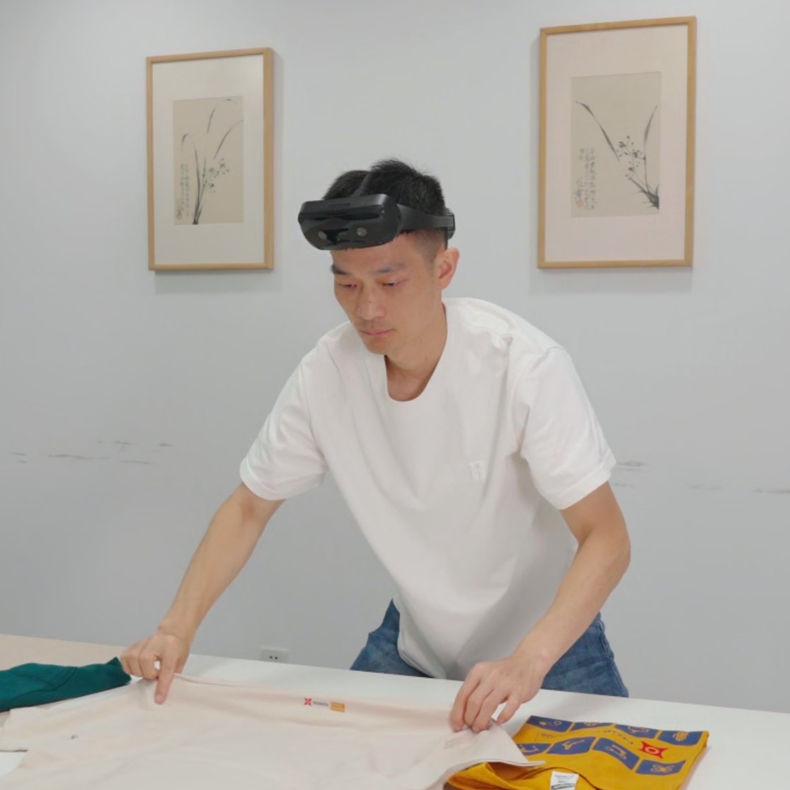 采集人员佩戴 TOBI E6 在桌面折叠衣物的真实家庭服务场景